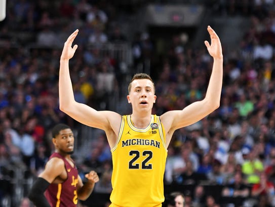 Michigan guard Duncan Robinson tries to get the Michigan