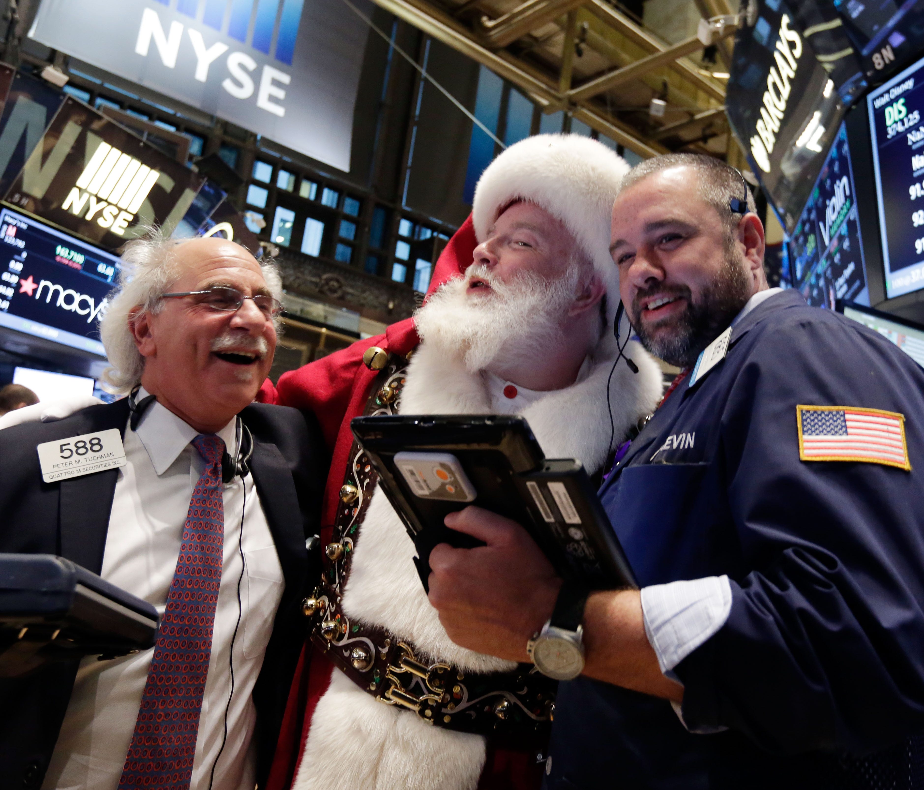 Traders pose with Santa on the floor of the New York Stock Exchange in 2014. Stock indexes are holding near record levels as traders digest some mixed news on the U.S. economy.