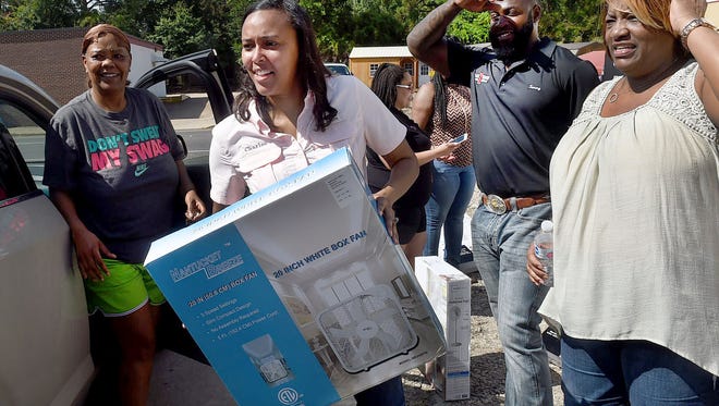 Charllee Renaud Lear distributes electric fans and bottled water to Opelousas residents Saturday near her Landry Street law office. Lear partnered with Black Widow Outdoor Services LLC to donate fans to needy residences to help combat the hot summer months ahead. Lear, a local attorney is also a running in November for the office of mayor of the city of Opelousas. See more photos at dailyworld.com and on the Daily World Facebook site.