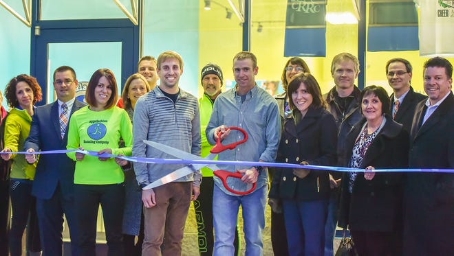 Josh Beck, owner of Appalachian Running Co. holds a pair of scissors during the ribbon-cutting ceremony opening at the store at 1640 Orchard Drive in Chambersburg, on Wednesday, Jan. 7, 2015. Appalachian Running Co. has another store in Carlisle.