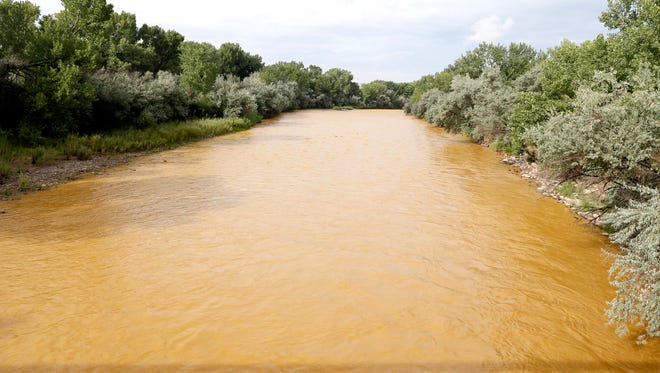 The discolored Animas River flows through Berg Park in Farmington on Aug. 8, 2015, shortly after the Gold King Mine spill.