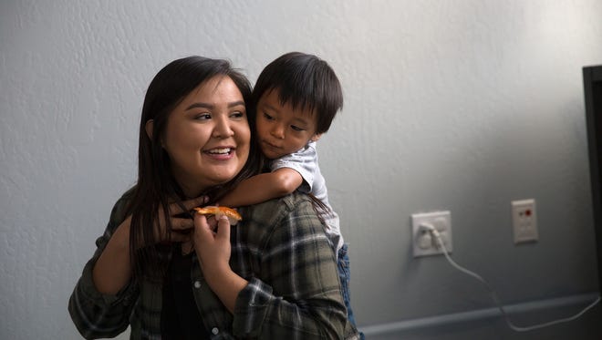 Bria Betonie, left, plays with her son Davien Alfred Friday at New Mexico First Born's new headquarters in Farmington. The organization is celebrating its move with a ribbon-cutting ceremony Friday.