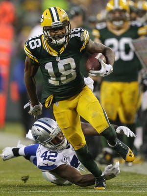 Green Bay Packers receiver Randall Cobb runs for yardage on a reception against Dallas Cowboys safety Barry Church at Lambeau Field.