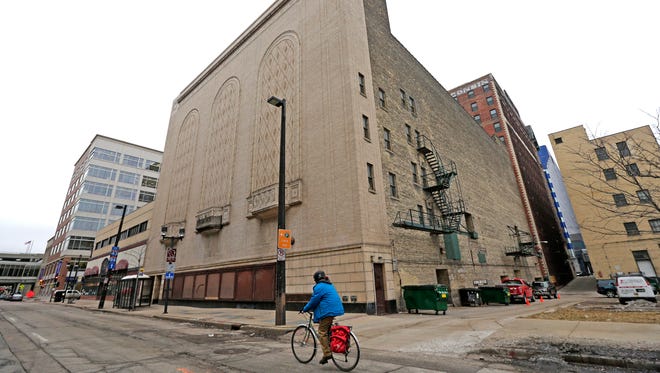 A cyclist rides past the back of the Warner Grand Theatre on N. 2nd St. in Milwaukee. The theater's back wall will be separated from the historic building and moved about 30 feet into N. 2nd St. as part of a planned conversion of the former theater into the Milwaukee Symphony Orchestra's new performance hall. The wall has to be moved to accommodate an expanded stage for the orchestra.
