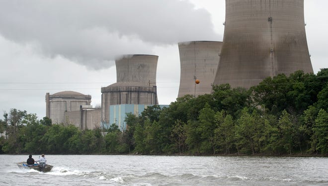 A boat makes its way past the towers of Three Mile Island in 2017. Three Mile Island will close in September 2019, following five years of losses, said plant owner Exelon Corp.