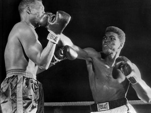 Muhammad Ali (Cassius Clay), right, lands on Don Warner's jaw in an early exchange of their fight in Miami Beach, Fla., February 28, 1962 with a straight right. It was the same punch which knocked Warner through the ropes in Round 4 and headed him for a technical knockout as the fight was stopped soon after he climbed back to the canvas.