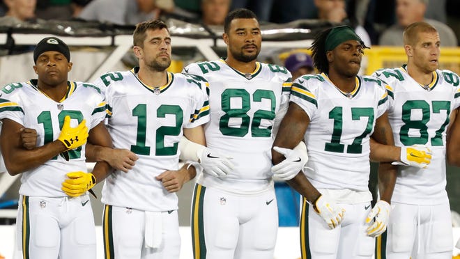 Green Bay Packers link arms during the national anthem before an NFL football game against the Chicago Bears Thursday, Sept. 28, 2017, in Green Bay, Wis. (AP Photo/Matt Ludtke)