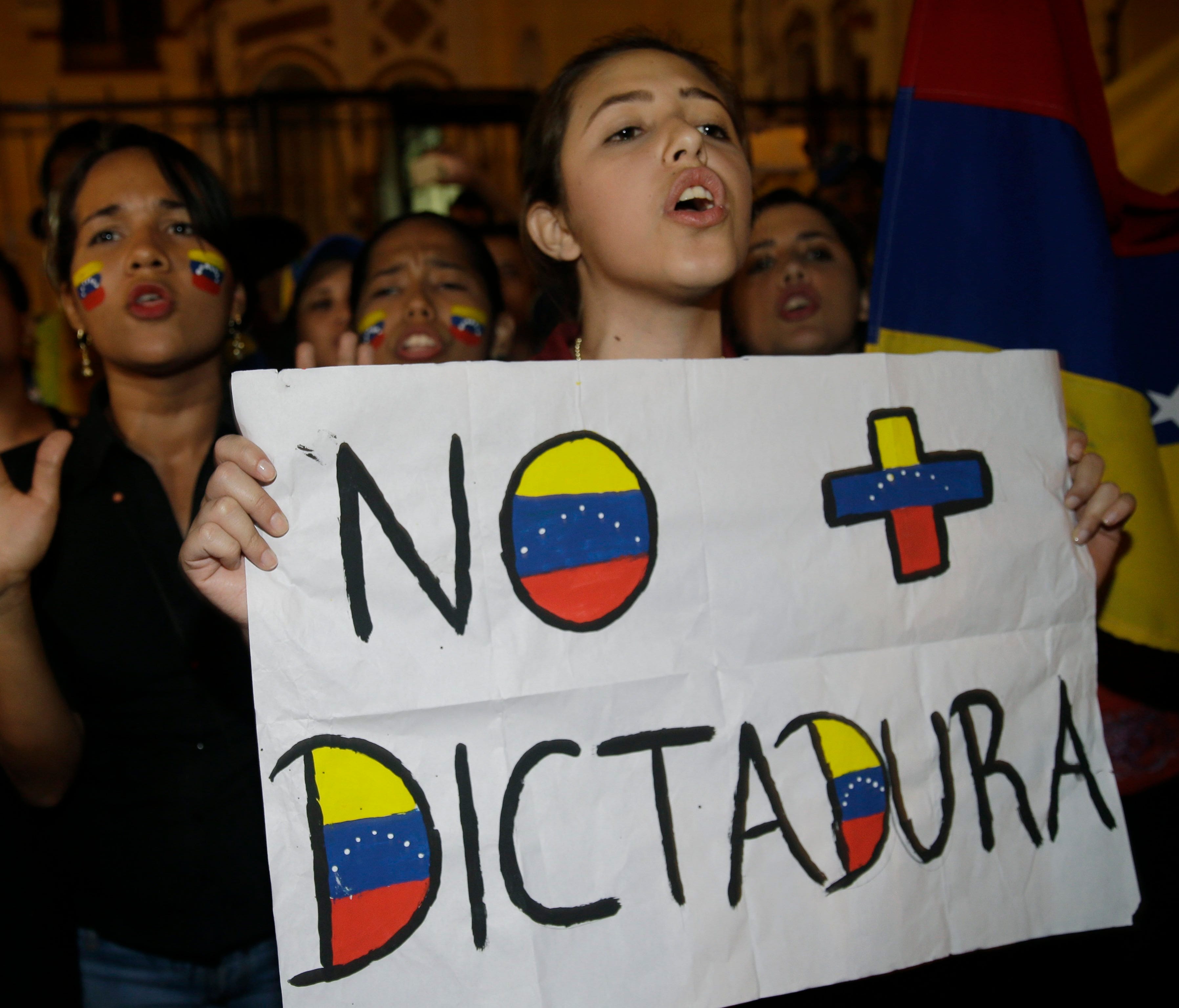 Protesters shout slogans against Venezuela's government and Venezuelan President Nicolas Maduro.