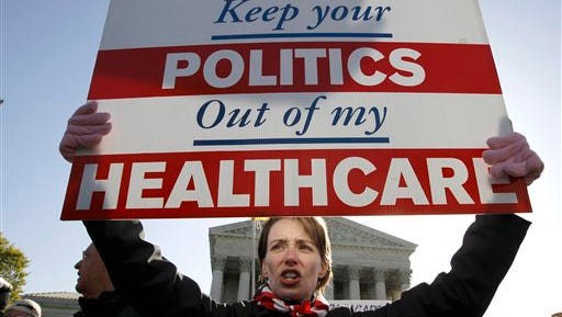 FILE - In this March 27, 2012 file photo, Amy Brighton from Medina, Ohio, who opposes health care reform, holds a sign in front of the Supreme Court in Washington during a rally as the court continues arguments on the health care law signed by President Barack Obama. Most Americans want the Supreme Court to side with the government when it decides whether the feds can continue subsidizing insurance premiums in all 50 states under President Barack Obama’s health care law, according to polls in recent months. (AP Photo/Charles Dharapak, File)