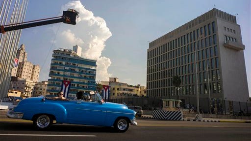 Tourists ride in a vintage American car in front of the U.S. embassy in Havana, Cuba, Thursday, Aug. 13, 2015.