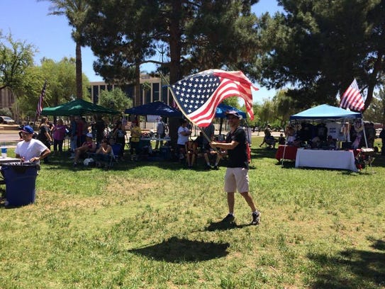 Russell Jaffe waves a flag at a rally outside the Arizona