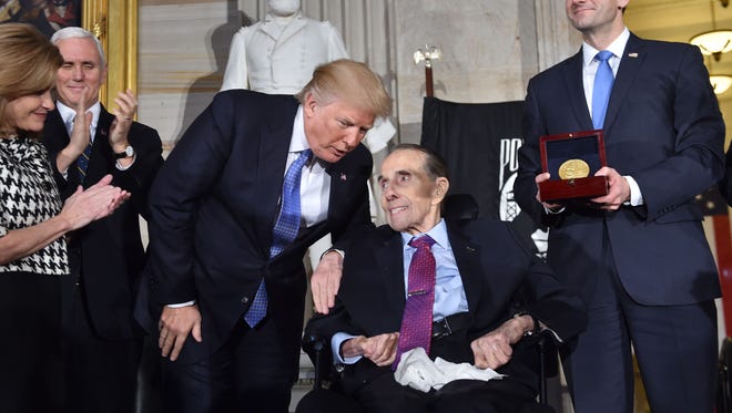 President Trump speaks to former U.S. Senate majority leader Bob Dole, R-Kan., center, at a ceremony where Dole was presented the Congressional Gold Medal held here by Speaker of the House Paul Ryan, R-Wis., as Rep. Lynn Jenkins, R-Kan., and Vice President Pence watch.