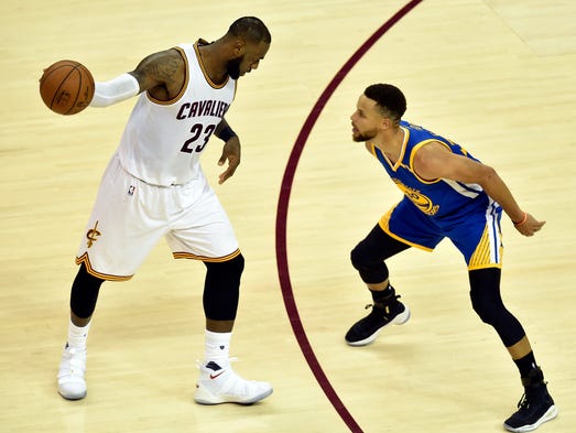 LeBron James handles the ball against Stephen Curry