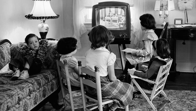 FILE - In this Jan. 6, 1953, file photo, four children watch a television in Baltimore, Md. Ever since freckle-faced puppet Howdy Doody ushered in children’s television nearly 70 years ago, each new generation of viewers has been treated to a growing bounty of programs on a mushrooming selection of gadgetry. Even so, it may be surprising that youngsters watch most television on a television. Just as their elders mostly still do, and always did, since TV first began. (AP Photo, File)