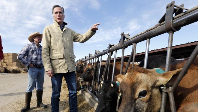 Former Republican presidential candidate Mitt Romney stands near cows during a tour of Gibson's Green Acres Dairy Friday, Feb. 16, 2018, in Ogden, Utah. The 2012 Republican presidential candidate plans to bid for the seat being vacated by retiring seven-term Utah Sen. Orrin Hatch.