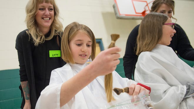 Jason Mynatt secures bundles of his hair in a bag after a hair donation assembly at Zach Elementary School on Friday, January 26, 2018. Mynatt, a fourth grader, grew his hair out for three years just so he could donate to Locks of Love. 