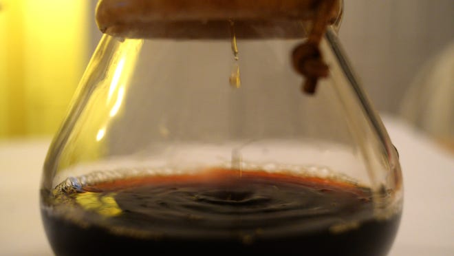 Brewed coffee drips into the bottom portion of the glass Chemex. Before spending money on cool brewing devices, the author suggests purchasing a grinder first.