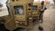Iraqi soldiers stand next to their vehicle in the village