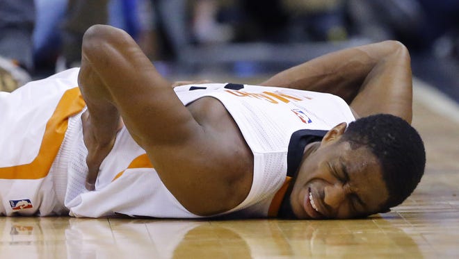 Phoenix Suns guard Brandon Knight (3) reacts after getting kneed in the back by Minnesota Timberwolves forward Shabazz Muhammad (15) while fighting for a loose ball in the second half of their NBA game Sunday, March 14, 2016 in Phoenix, Ariz.