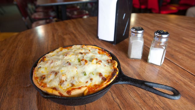 Bonnie & Clyde's Pizzeria's "Italian Pie" is a deep dish pizza made with Canadian bacon, pepperoni, Italian sausage, ground beef, mushrooms, black and green olives, green popers and onions made in several mozzarella-topped layers. The medium and large versions are served table side in a cast-iron pan while the small Italian Pie (seen here) is either served in the pan or on a dish. Feb. 21, 2018