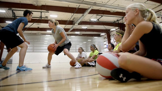 Milicia Jovanovic, a women's basketball player out of Turkey, helps former WNBA player Anna DeForge demonstrate how DeForge wants the students in her youth clinic to start their one-on-one games at Lake Park Sportzone Tuesday, July 14, in Menasha. DeForge held a clinic for fourth- through sixth-graders in the morning, and seventh- through 12th-graders in the afternoon.