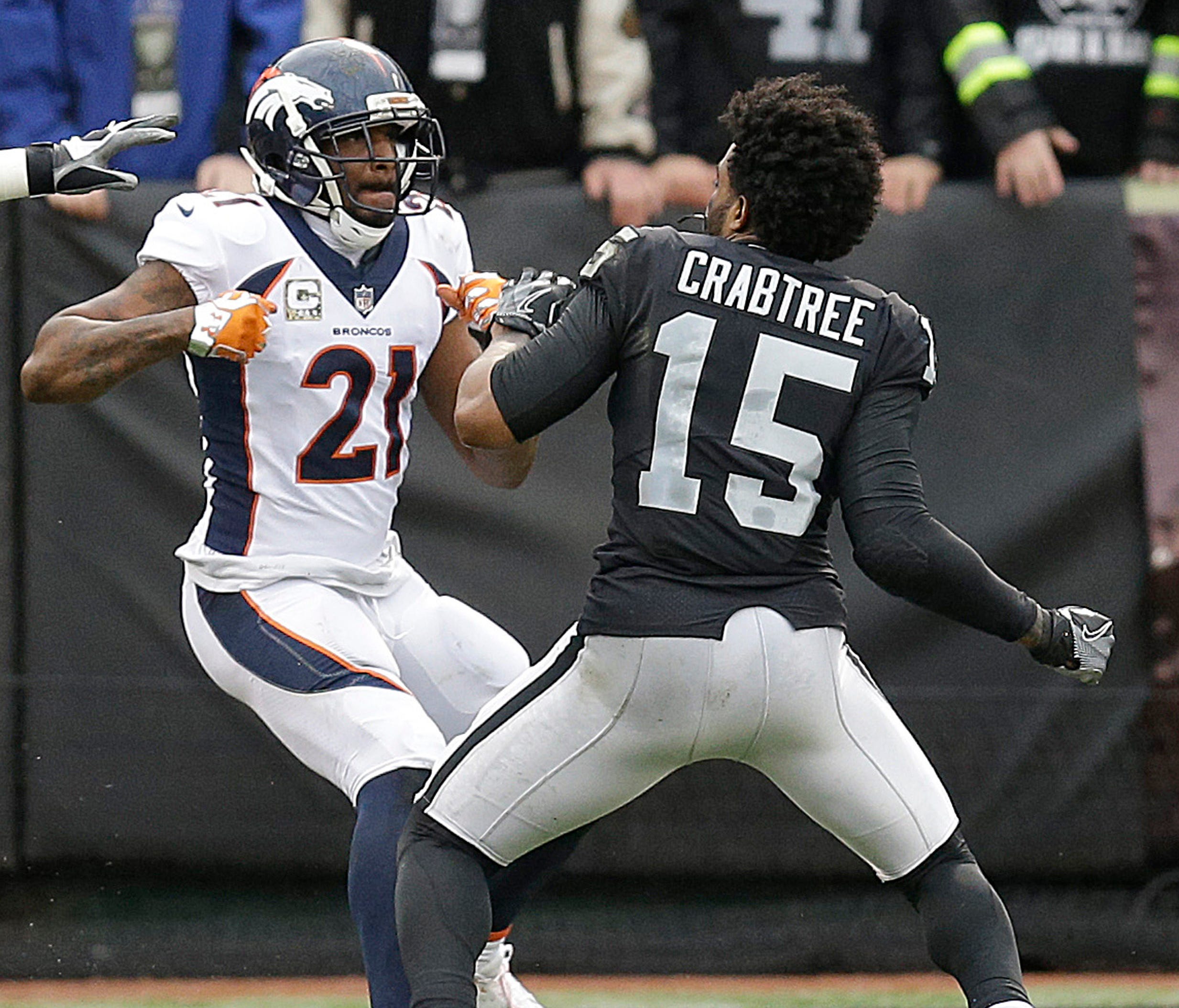 Denver Broncos cornerback Aqib Talib (21) fights Oakland Raiders wide receiver Michael Crabtree (15) during the first half of an NFL football game in Oakland, Calif., Sunday, Nov. 26, 2017.