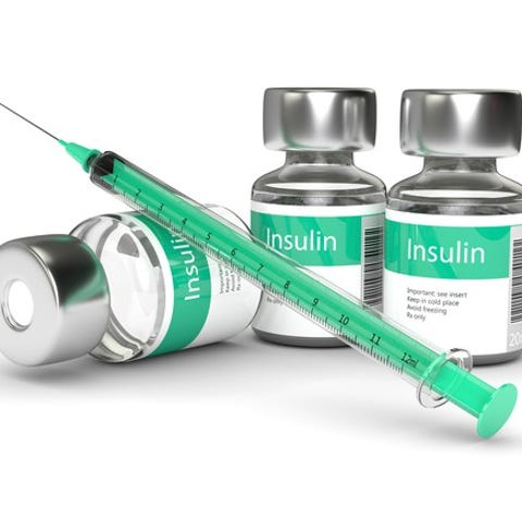 Insulin bottles and a syringe on a table