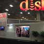 Booth at convention center with DISH setup, including wall and large-screen TV.