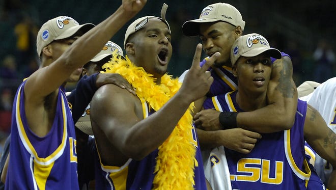 LSU's Garrett Templs (left) and Glen Davis (second from left) hold up two fingers to let the crowd know how many more wins they need before they are crowned national champions during the trophy presentation after defeating Texas in the Atlanta Regional Final in 2006.