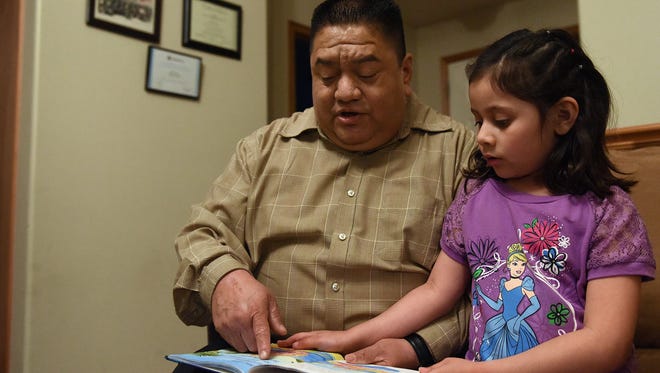 Otto Garcia reads the "Little Lost Dolphin" with his daughter, Rebeca, at their home in western Sioux Falls on Wed., April 27, 2016.