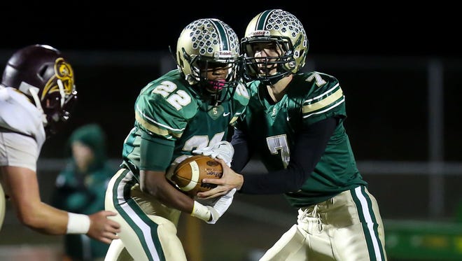 Running back Tyreese Snipe of Schalick takes a hand from quarterback Jared Fox during action in Friday's win over Gloucester Catholic. The Cougars wrapped up the WJFL Classic Division title with the victory.