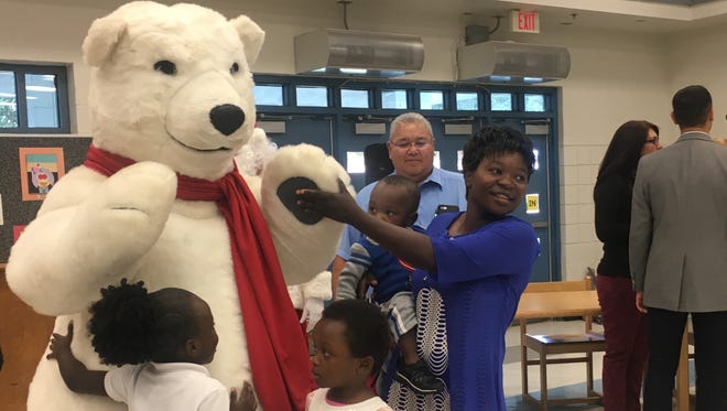 The Coca-Cola polar bear greets children and their families during Walmart's "Gift of Giving" event Dec. 15, 2017, at Alhambra Elementary School District's Family Resource Center in Phoenix.