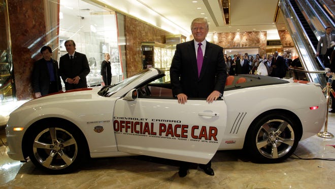 Donald Trump poses with a replica of the 2011 Indianapolis 500 Chevrolet Camaro pace car during a news conference at the Trump Tower on April 5, 2011.