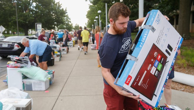 Austin Vanden Berg, of Lake of the Ozarks, helps his girlfriend during move-in day at Missouri State University on Friday, August 18, 2017.