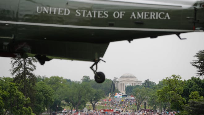 Climate Change rally on the National Mall is seen in the distance as Marine One helicopter, with President Donald Trump aboard, lifts off from South Lawn of the White House in Washington, Saturday, April 29, 2017, for the short flight to Andrews Air Force Base, Md.