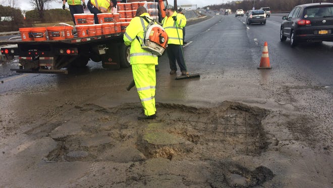Delaware Department of Transportation crews work to repair a pothole, closing two lanes of I-95 North between the Newark toll plaza and Del. 896.