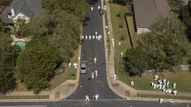 Investigators on Monday March 19, 2018, work at the scene of a bomb explosion on Dawn Song Drive in Austin, Texas, that seriously injured two men Sunday. Two people have now been killed and four wounded in bombings over a span of less than three weeks. ( Jay Janner/Austin American-Statesman via AP)