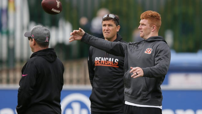 FILE - In this Oct. 28, 2016, file photo, Cincinnati Bengals quarterback Andy Dalton, right, warms up, watched by quarterback coach Bill Lazor, center, before NFL football practice session at Allianz Park in London, England. After starting 0-2, the Bengals fired offensive coordinator Ken Zampese and replaced him with quarterbacks coach Bill Lazor. He’ll make his debut in his new role this week against the Packers. (AP Photo/Tim Ireland, File)