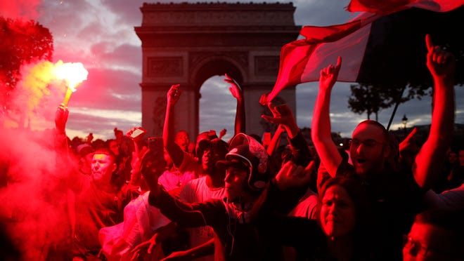 People celebrate on the Champs Elysees avenue, with the Arc de Triomphe in background, after the semifinal match between France and Belgium at the 2018 soccer World Cup, Tuesday, July 10, 2018 in Paris. France advanced to the World Cup final for the first time since 2006 with a 1-0 win over Belgium on Tuesday. (AP Photo/Thibault Camus)