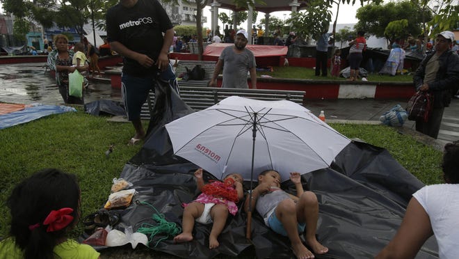 Central American children traveling with a caravan of thousands of migrants rest on a plastic tarp as their parents set up camp in a public park, after arriving to Huixtla, Mexico, Monday, Oct. 22, 2018. Thousands of Central American migrants resumed an arduous trek toward the U.S. border Monday, with many bristling at suggestions there could be terrorists among them and saying the caravan is being used for political ends by U.S. President Donald Trump. (AP Photo/Moises Castillo)
