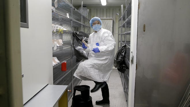 Ivana Vu, an airborne sensor operator, prepares newly sterilized N95 masks in Waukegan, Ill. The mask sterilization site is operated by Battelle, which received a FEMA contract. Officials say the site can sterilize as many as 80,000 masks a day.
