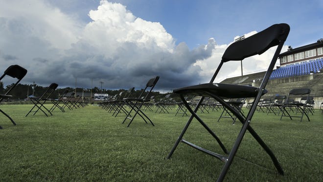 Empty chairs sit on the football field at Tuscaloosa County High as clouds loom to the north. Graduation for TCHS, Hillcrest and Brookwood was postponed due to the threat of rain and will be held Friday night.