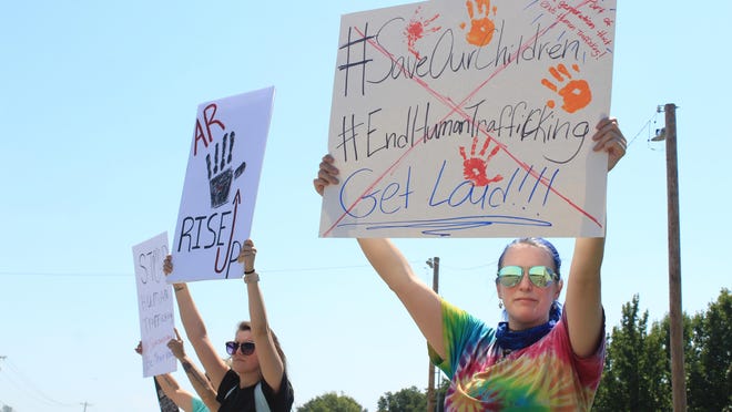 Christina Jones of Panama, from right, Courtney Sirratt and Melinda Sirratt of Bonanza raise signs against human trafficking at a Save Our Children rally on Saturday, Aug. 22, 2020, on Zero Street near Ben Geren Park in Fort Smith.