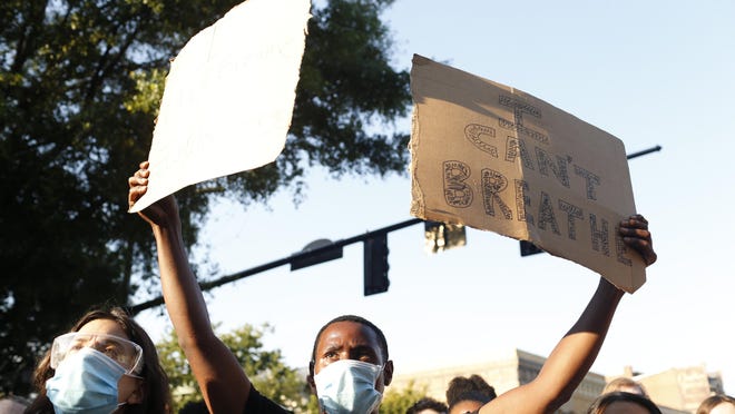 Protesters block Broad Street after marching through the streets in downtown Athens on Sunday. The protest was organized in response to the death of George Floyd, who died in police custody in Minneapolis, sparking demonstrations and riots around the country.