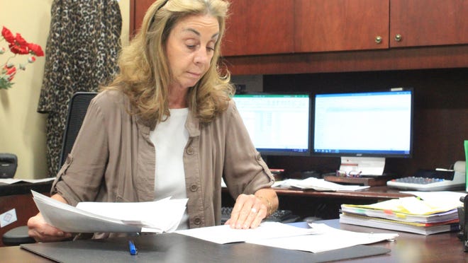 Sebastian County Circuit Clerk Denora Coomer looks through court records on Tuesday, Dec. 1, 2020, inside her office at the county courts building. Coomer is retiring after 37 years in the Sebastian County legal system.