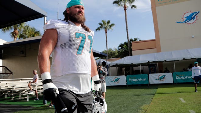 Miami Dolphins offensive guard Josh Sitton walks onto the field at the NFL football team's training camp, Friday, July 27, 2018, in Davie, Fla. (AP Photo/Lynne Sladky)