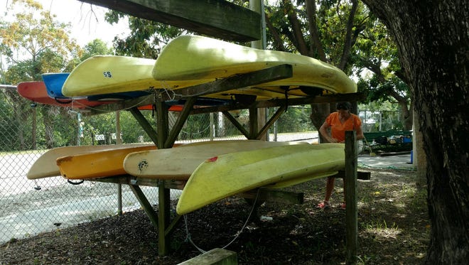 A Cape Coral parks worker prepares kayaks for the opening of the season on Nov. 5 at the Kayak Shack Outpost at Four Mile Cove Ecological Preserve.
