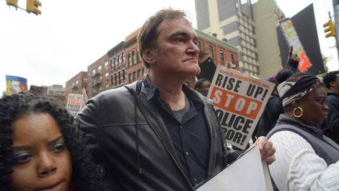 Director Quentin Tarantino, center, participates in a rally to protest against police brutality Saturday, Oct. 24, 2015, in New York. Speakers at the protest said they want to bring justice for those who were killed by police.