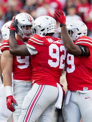 Sep 19, 2015; Ohio State Buckeyes defensive lineman Adolphus Washington (92) is congratulated by Buckeyes defensive linemen Joey Bosa (97) and Tyquan Lewis (59) after a sack against the Northern Illinois Huskies at Ohio Stadium. Ohio State won the game 20-13.