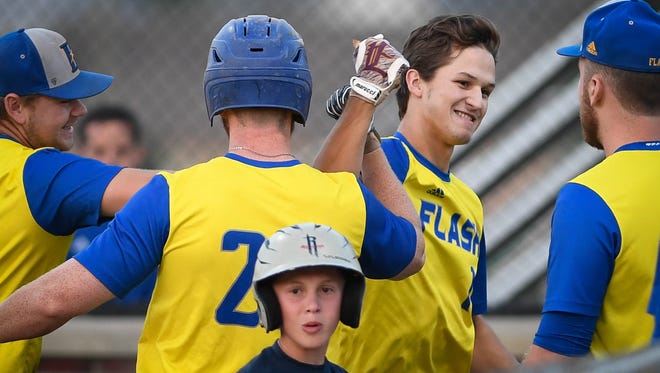 Flash's Evan Keller (12) is congratulated by teammates after hitting a two run homer as the Henderson Flash play the Dubois County Bombers in the Ohio Valley League playoffs at B.T. Wayne Field in Henderson Saturday, July 21, 2018.
